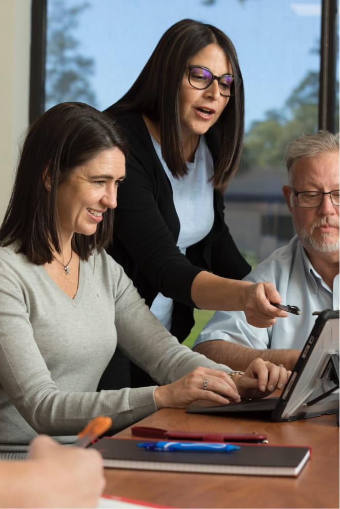 A group of employees looking at a computer