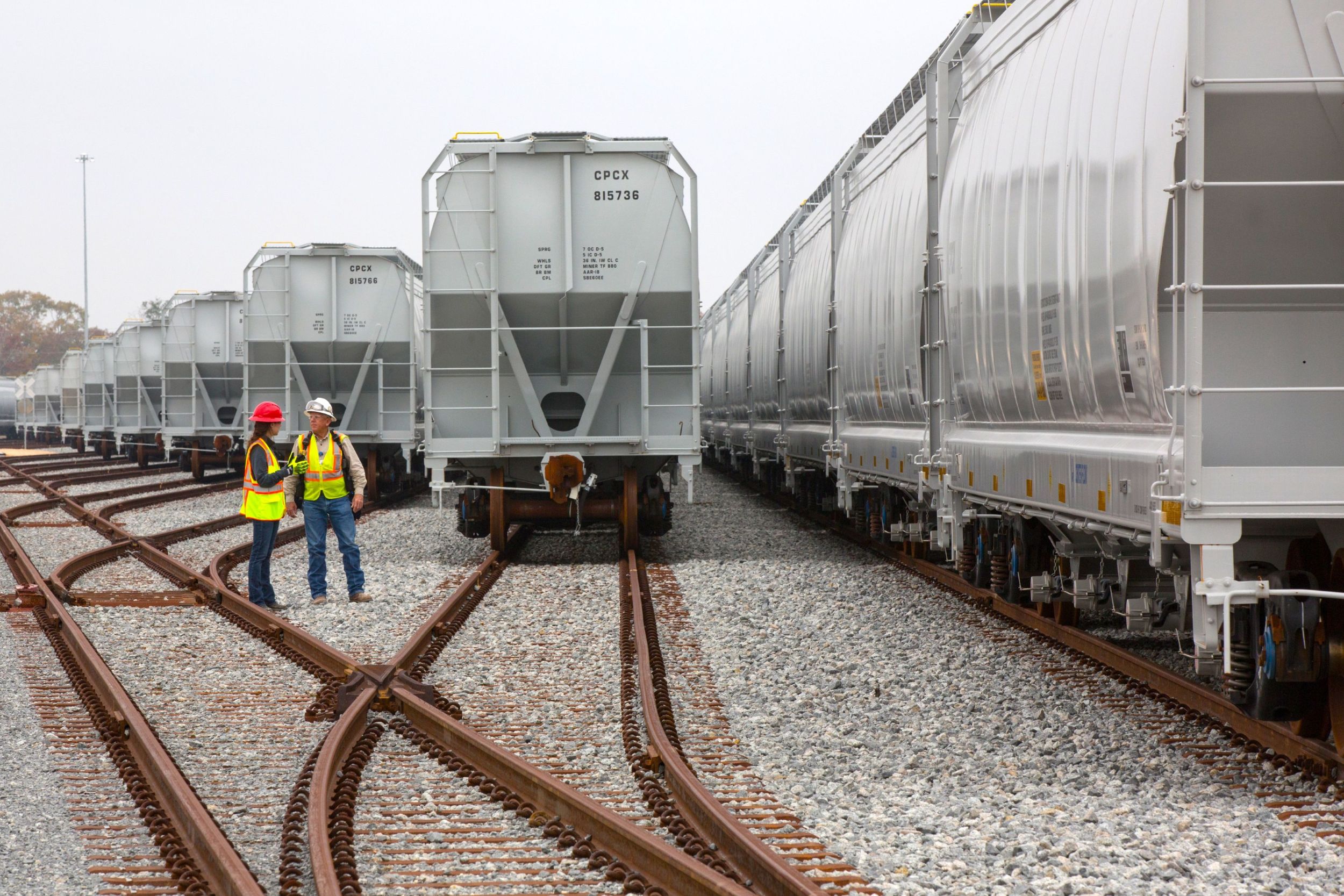 Employees next to railcars 