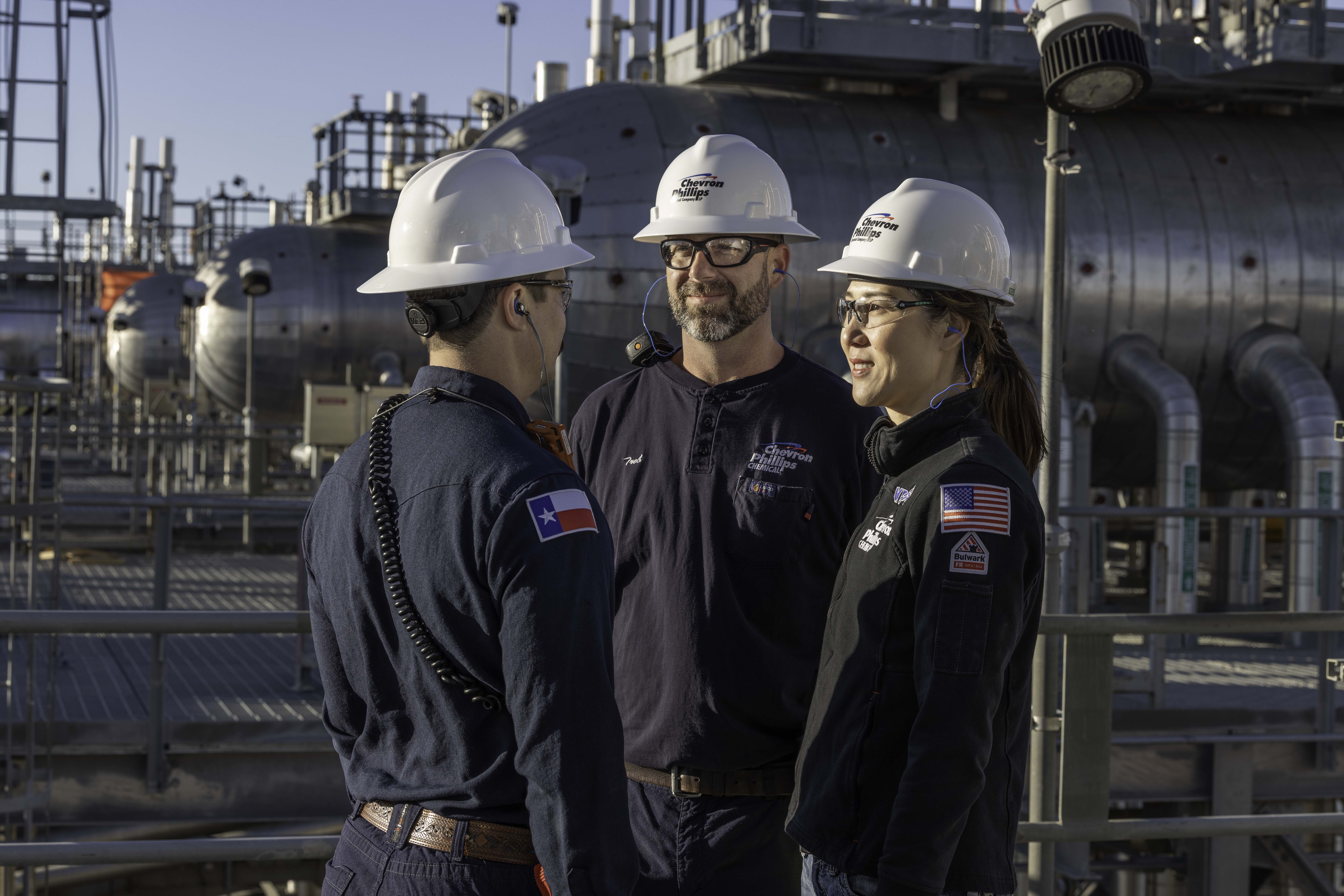 Three individuals standing together talking