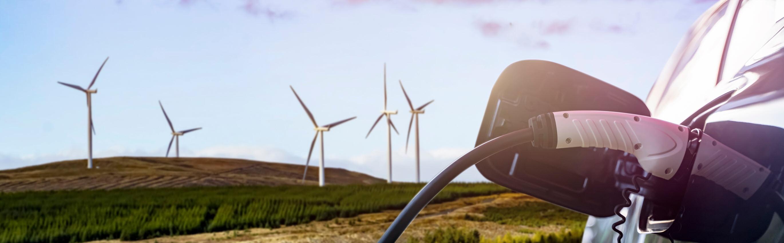 Electric Vehicle Charging with Wind Turbines in the background